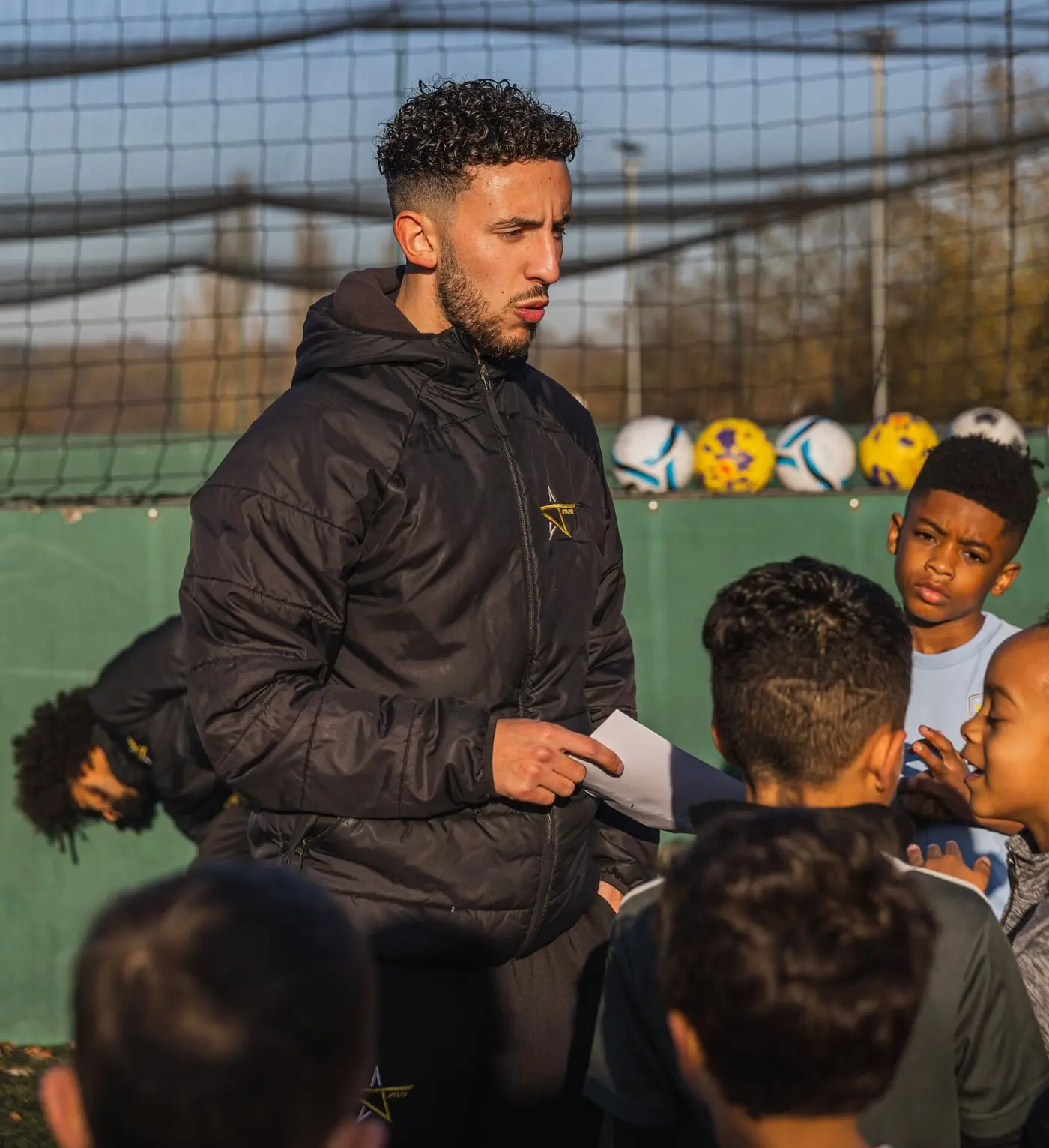 A J-Stars coach briefing his players during a session