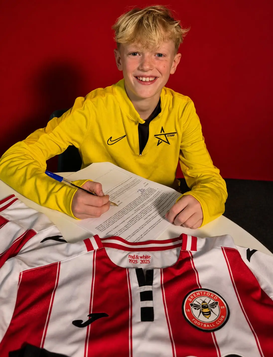 A J-Stars player signing his first club forms