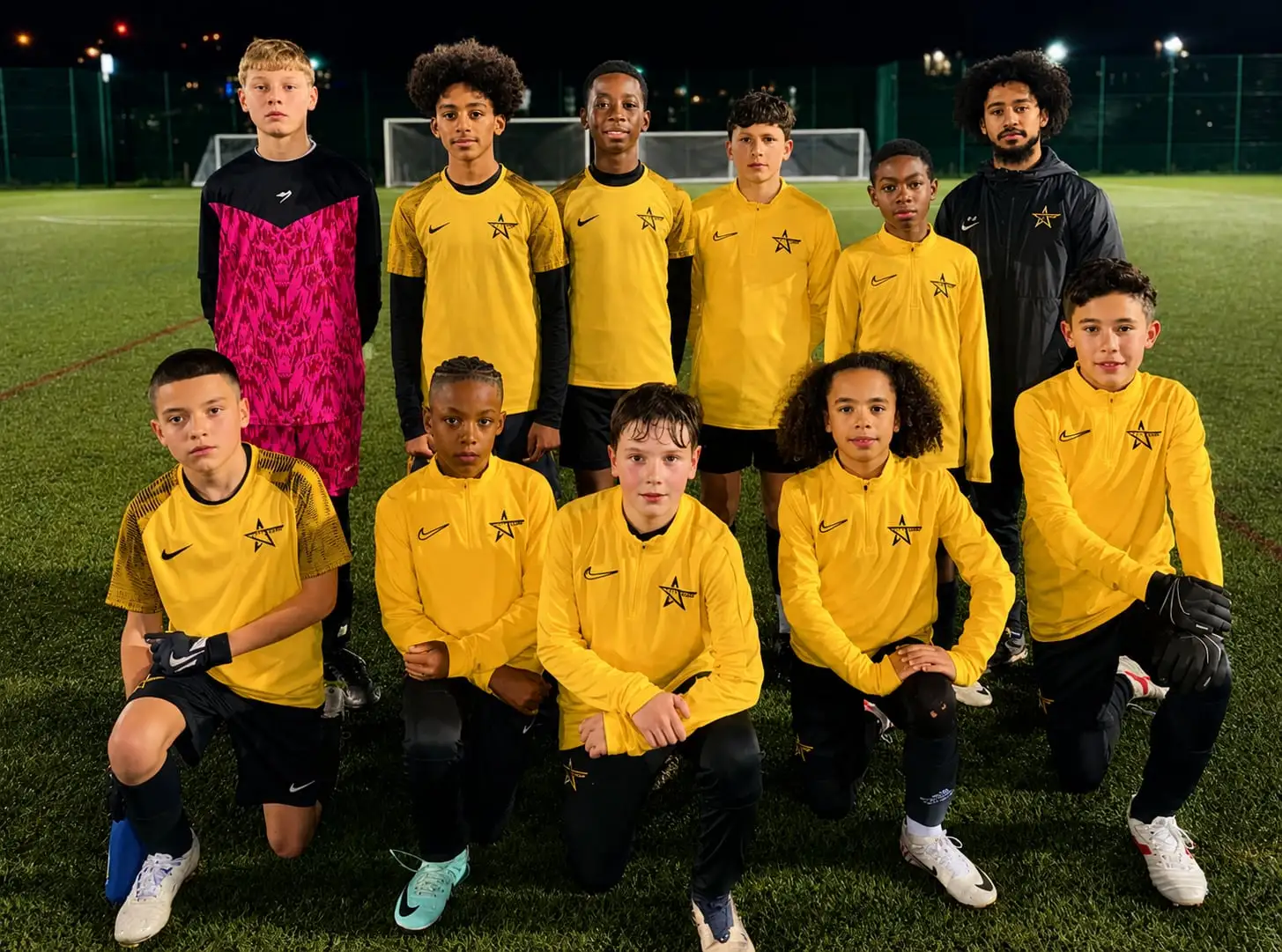 A J-Stars squad together on a floodlit pitch